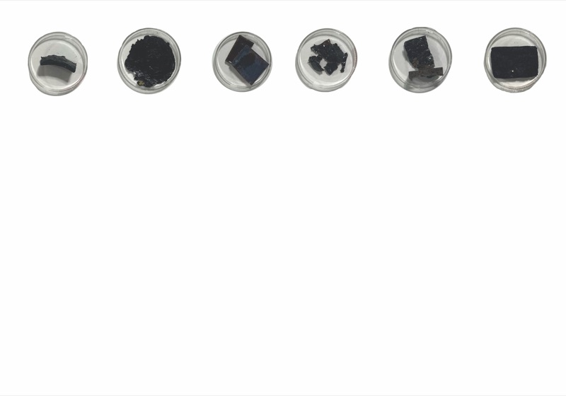 Six round dishes holding dark coffee-based samples