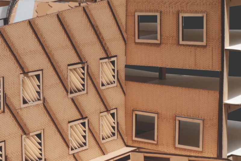 Card model of a brick-patterned facade with louvred windows